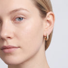 Model wearing the Lelice Rose Sparkle Hoops in gold, three-quarter face close-up