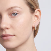 Model wearing the Lelice Rose Sparkle Hoops in gold, three-quarter face close-up
