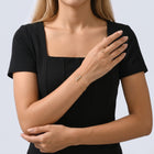Model wearing the Lelice Ruby Crystal Bracelet in gold, wrist resting across the body