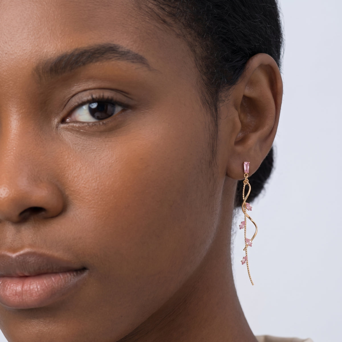 Model wearing the Lelice Santorini Blush Drops in gold, one-eye face close-up