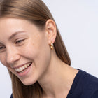 Model wearing the Lelice Sarah Minimal Hoops in gold, candid laugh