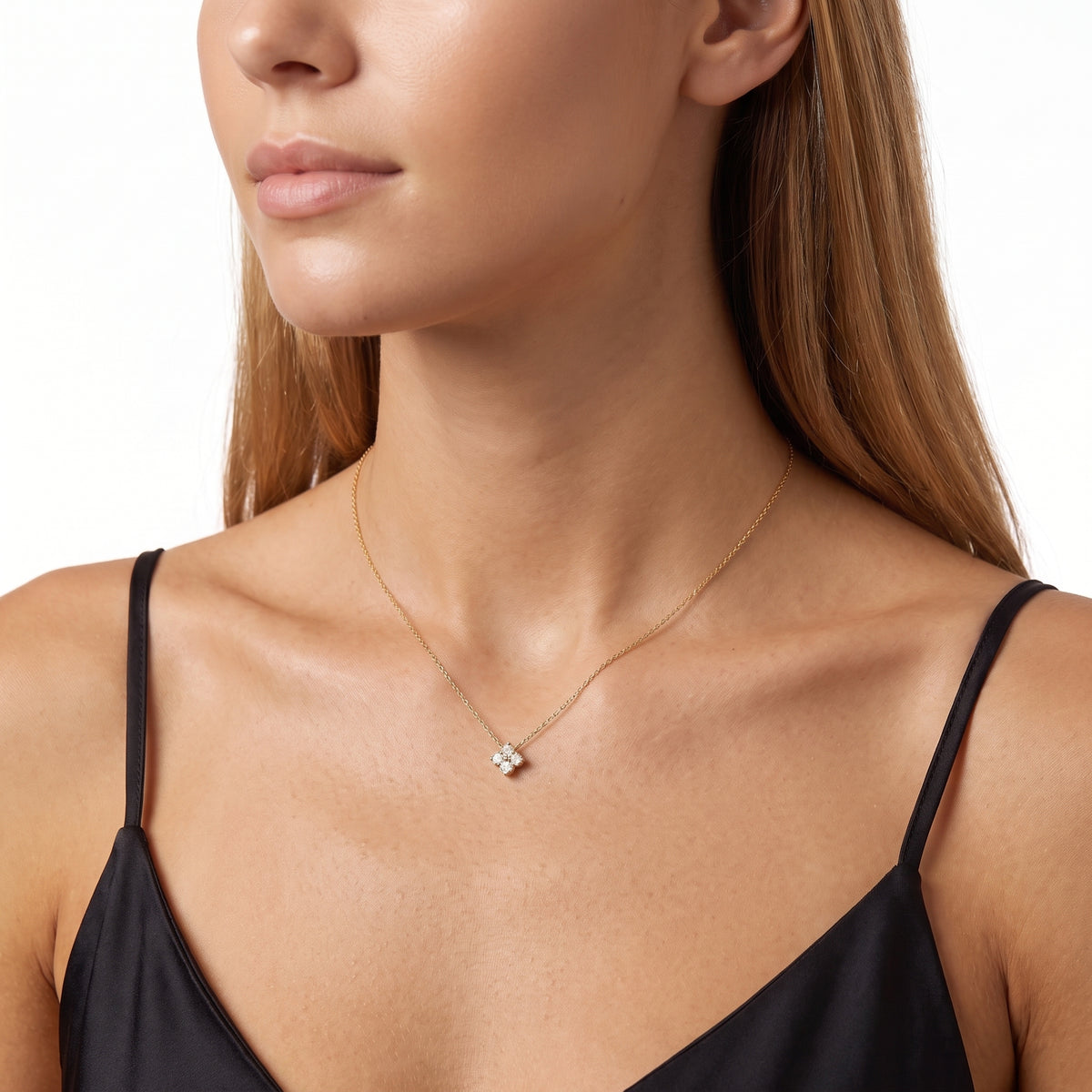 Side-lit profile of woman wearing Scarlett gold clover necklace