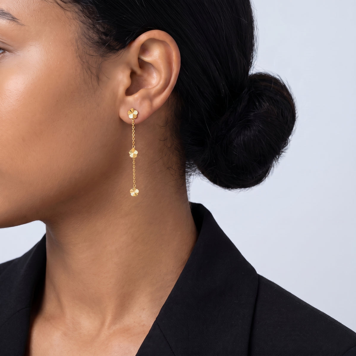 Model wearing the Lelice Senna Floral Earrings in gold, low bun, ear and neck