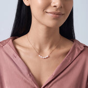 Woman with head tilted down wearing the Siena Pearl Necklace