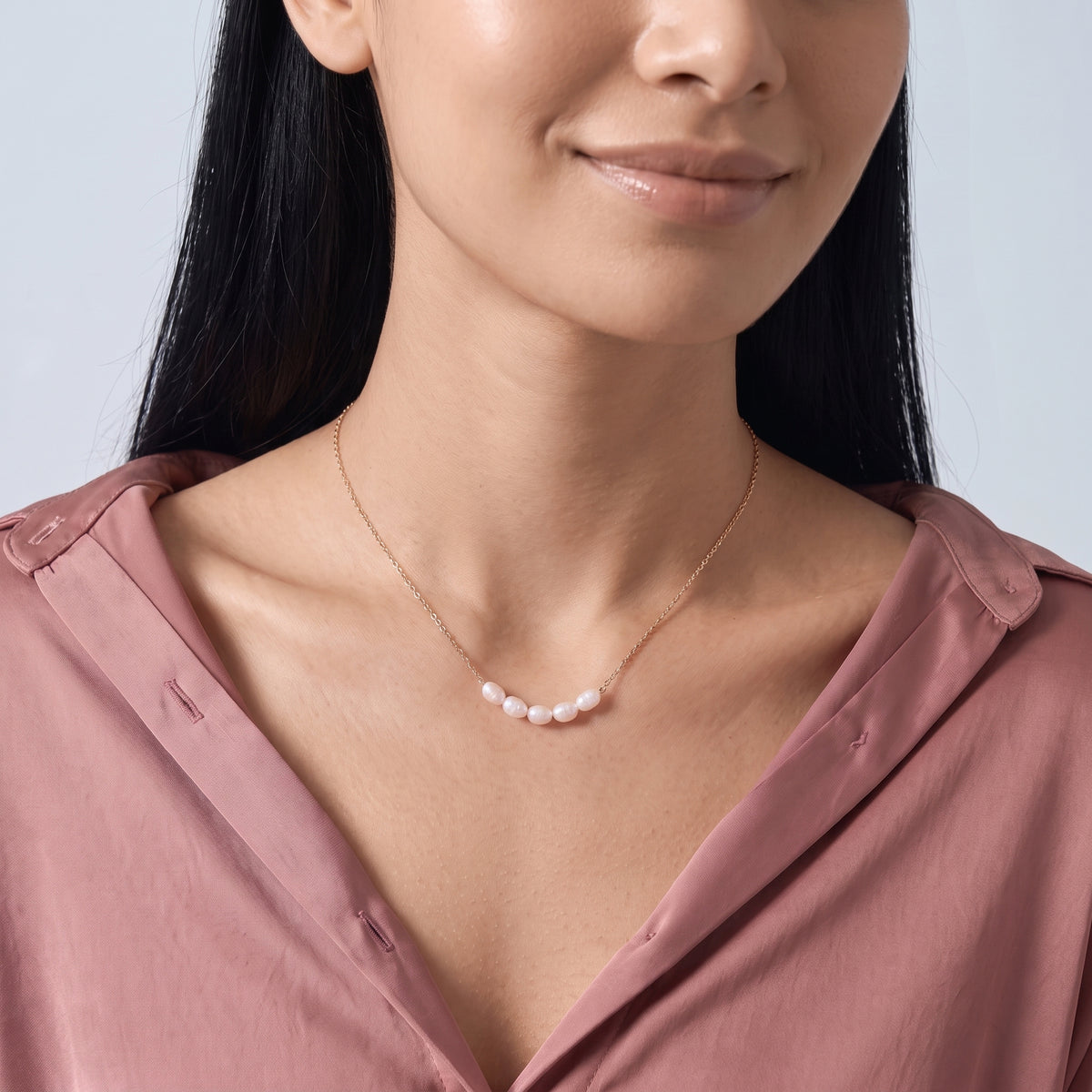Woman with head tilted down wearing the Siena Pearl Necklace