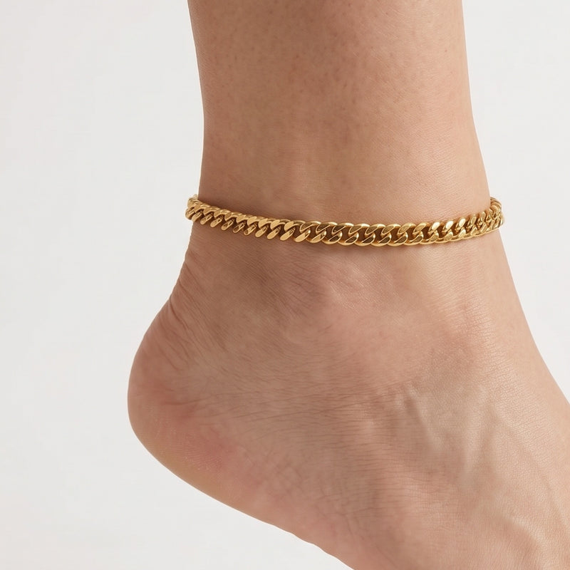 Close-up of the Lelice Sienna Cuban Chain Anklet in gold on a woman's ankle