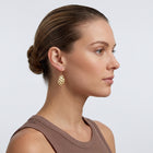 Model wearing the Lelice Sienna Drop Earrings in gold, slicked-back profile