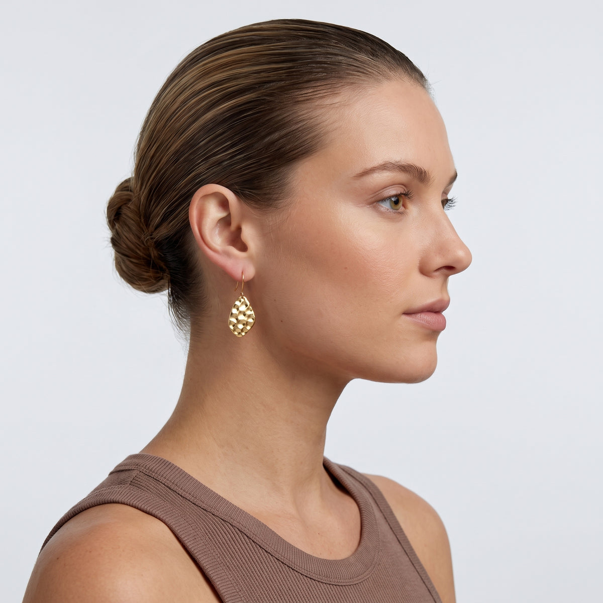 Model wearing the Lelice Sienna Drop Earrings in gold, slicked-back profile