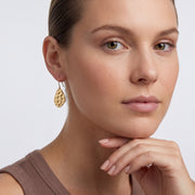 Model wearing the Lelice Sienna Drop Earrings in gold, hand at the chin
