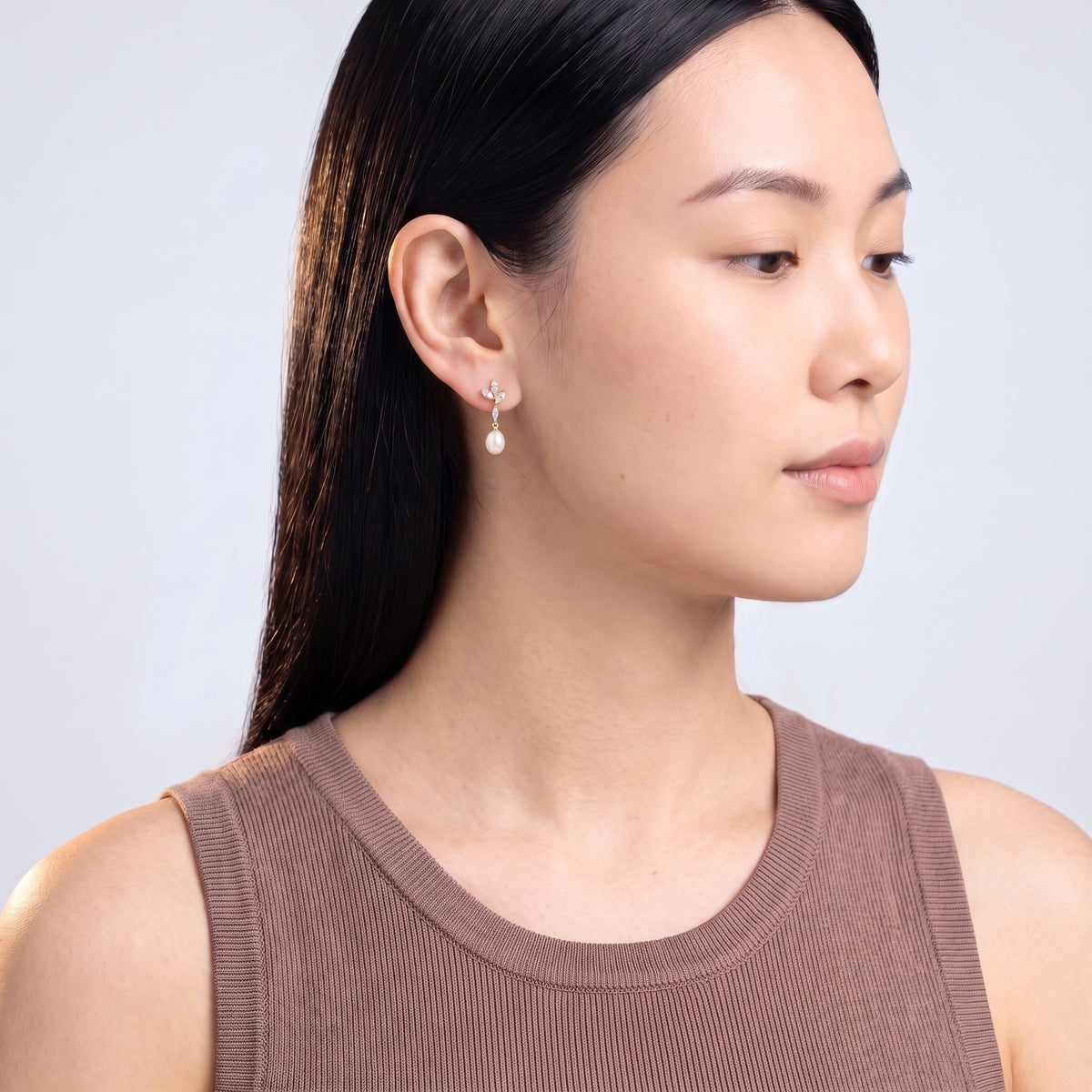 Model wearing the Lelice Simone Baroque Earrings in gold, turned toward the light
