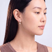 Model wearing the Lelice Simone Baroque Earrings in gold, downcast beauty portrait