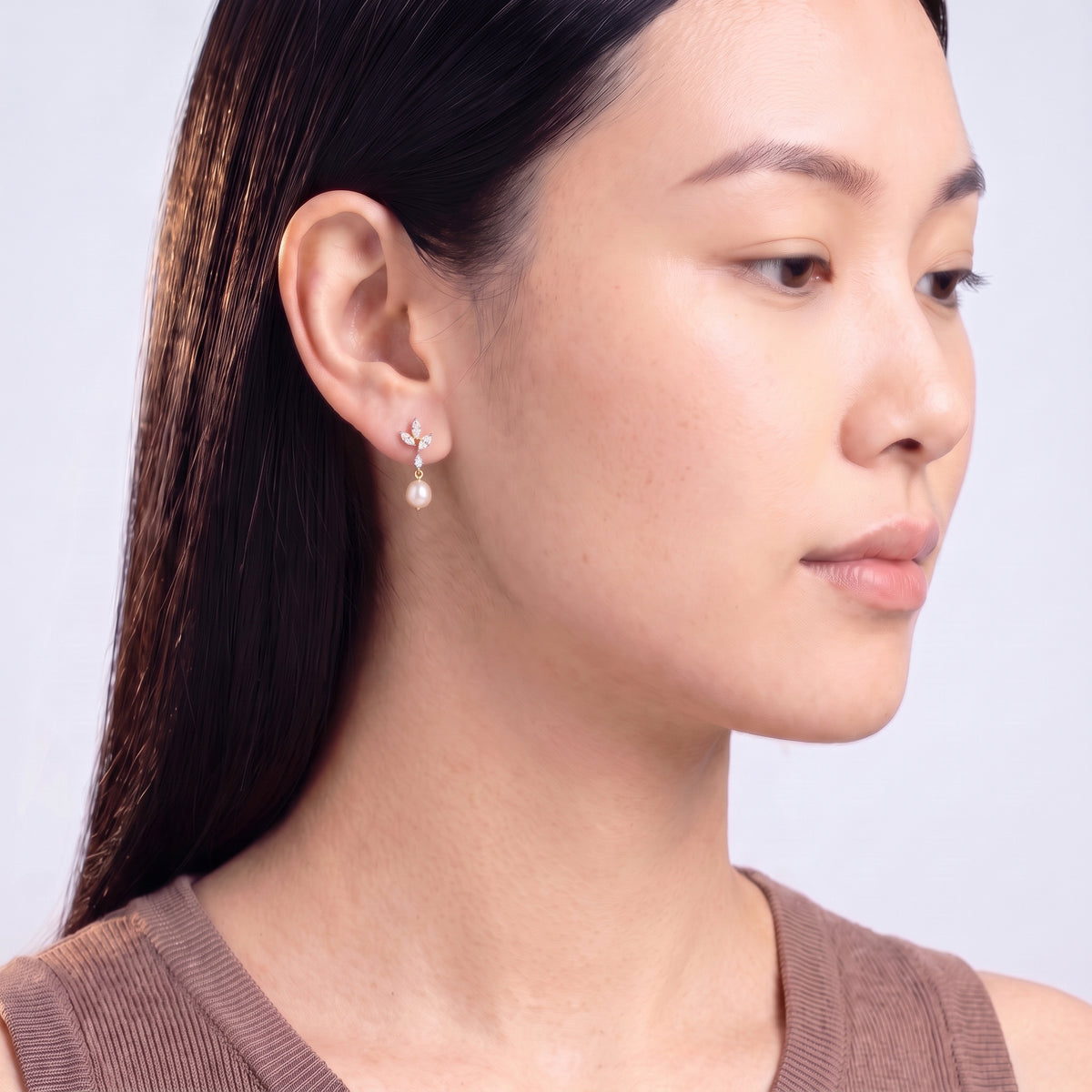 Model wearing the Lelice Simone Baroque Earrings in gold, downcast beauty portrait