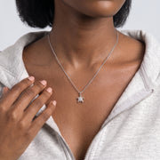 Hand at the collar of a woman wearing the Slow & Steady Silver Necklace