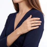 Arm folded across the body wearing Solène gold pavé ring
