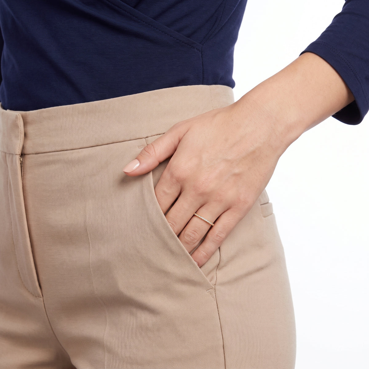 Hand in a trouser pocket wearing Solène gold pavé ring