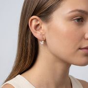 Model wearing the Lelice Sophie Pearl Hoops in gold, ear and jaw, slightly wider