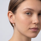 Model wearing the Lelice Sophie Pearl Hoops in gold, three-quarter face close-up