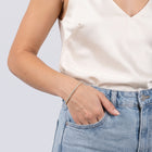 Model wearing the Lelice Sophie Tennis Bracelet in gold, hand in the jeans pocket