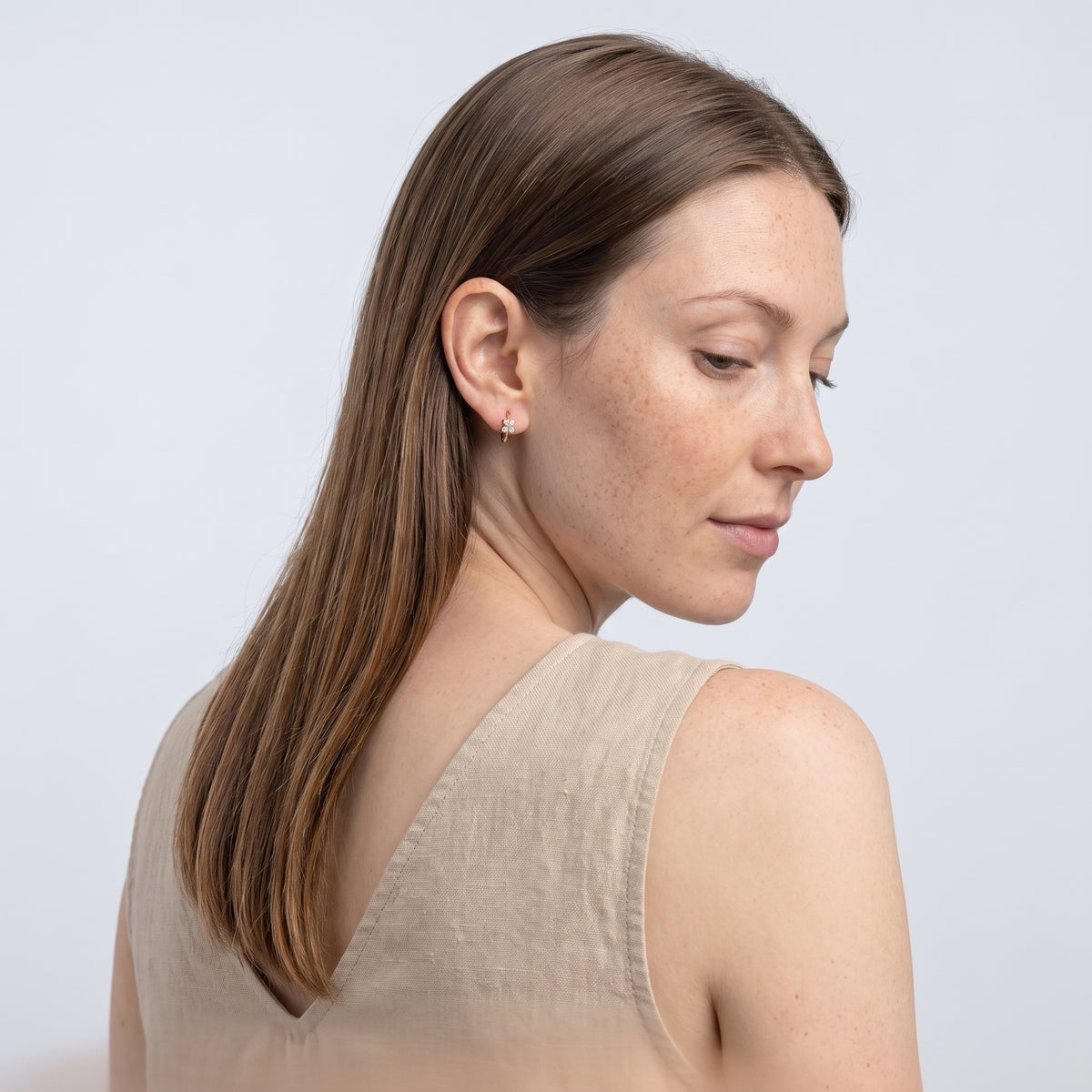 Model wearing the Lelice Sparkle Gold Hoops, over-the-shoulder glance