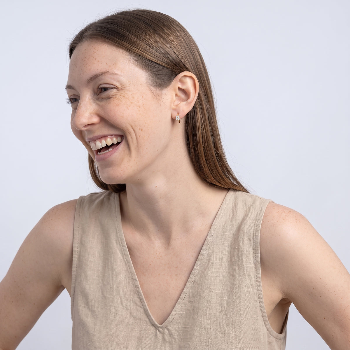 Model wearing the Lelice Sparkle Gold Hoops, candid laugh