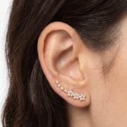 Close-up of the Lelice Stella Gold Flower and Star Crystal Ear Climbers on the ear
