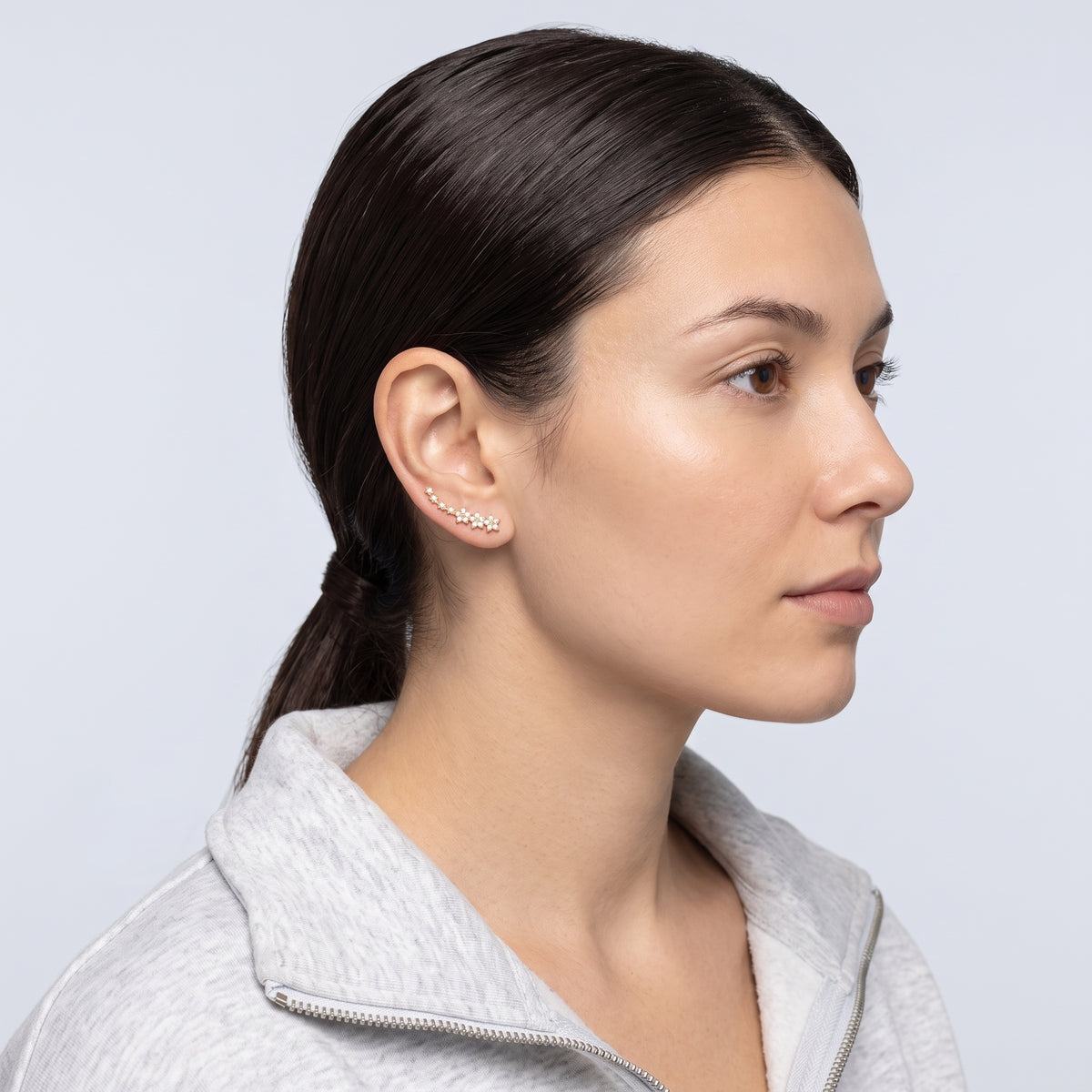 Model wearing the Lelice Stella Gold Flower and Star Crystal Ear Climbers, slicked-back profile