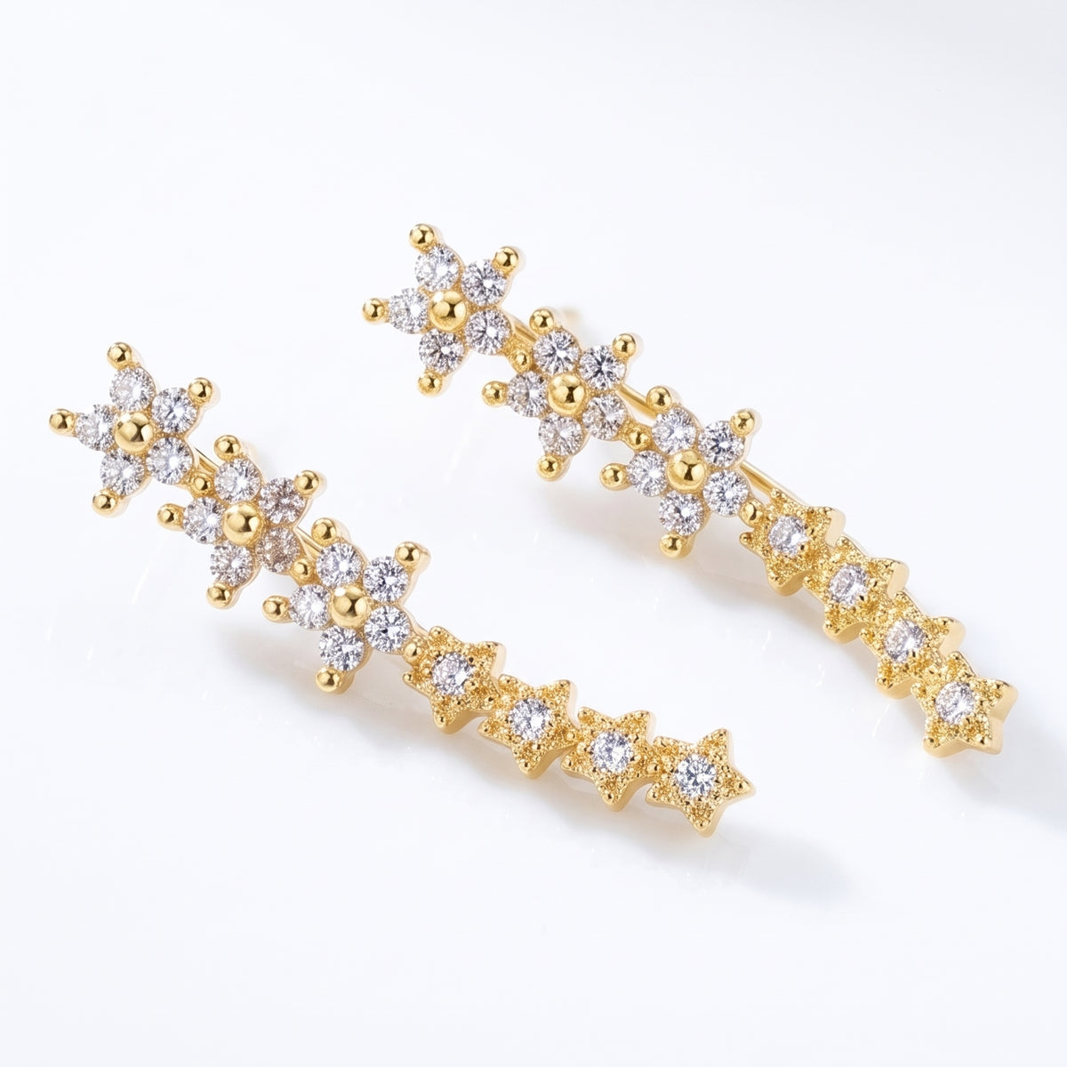 Lelice Stella Gold Flower and Star Crystal Ear Climbers on a white background