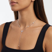 Woman turned three-quarters wearing the Sunburst Lariat Silver Necklace