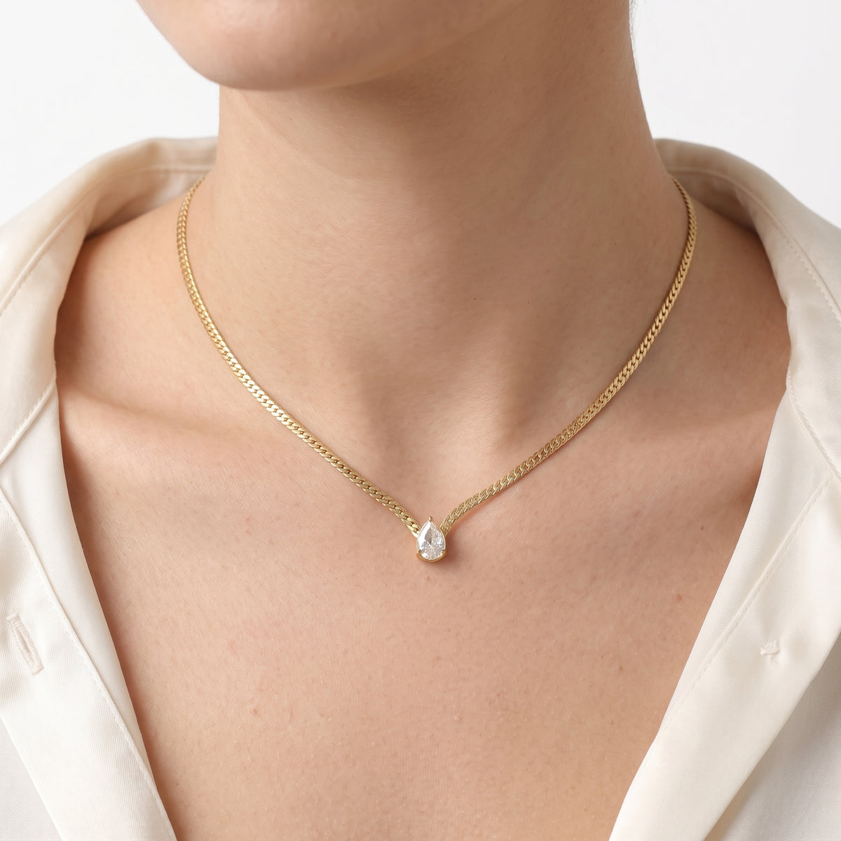 Close-up of the Lelice Teardrop Bezel Necklace in gold at the collarbone