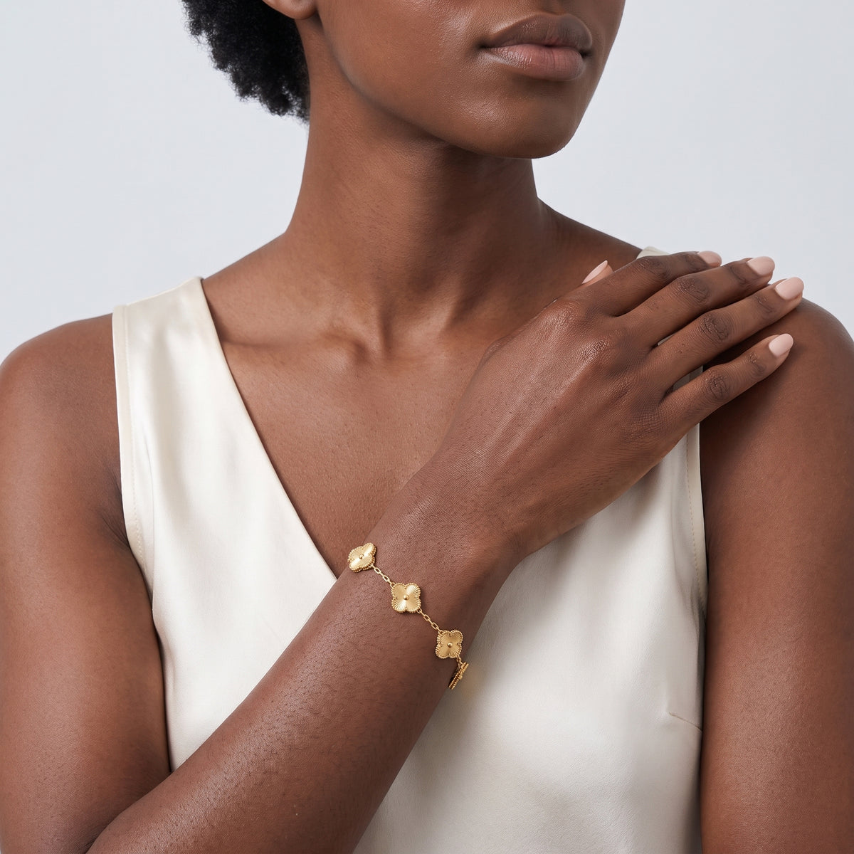 Model wearing the Lelice Tessa Gold Bracelet, hand on the opposite shoulder
