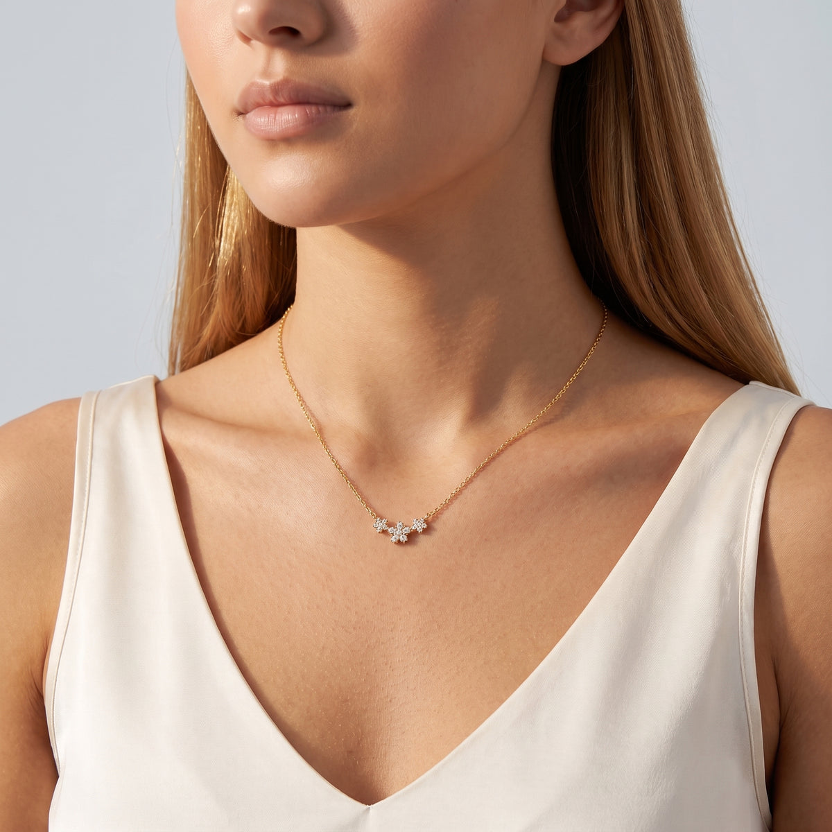 Woman in soft side light wearing the Blossom Trio Necklace