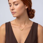 Neckline profile with hair up, wearing the Guardian Wings Necklace
