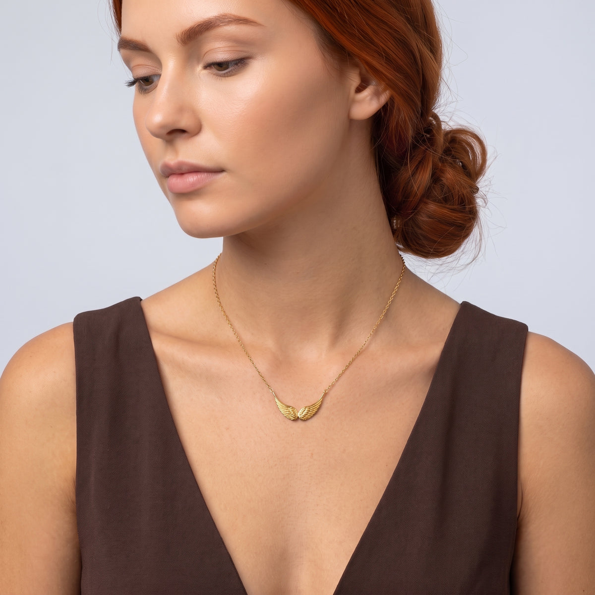Neckline profile with hair up, wearing the Guardian Wings Necklace