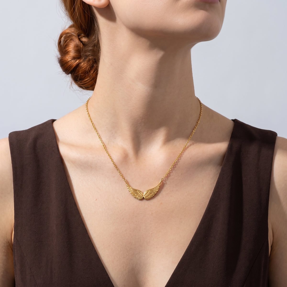 Low-angle portrait of a woman wearing the Guardian Wings Necklace