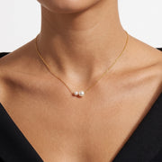 Close-up of the Lelice Pearl Duet Necklace in gold at the collarbone