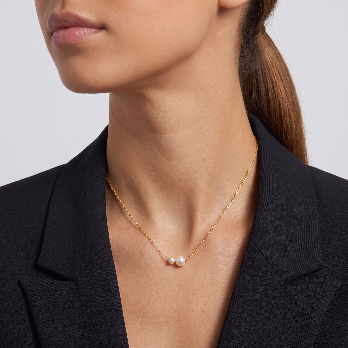 Side profile of the neckline with the Pearl Duet Necklace