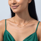 Woman with head tilted down wearing the Stardust Trail Necklace