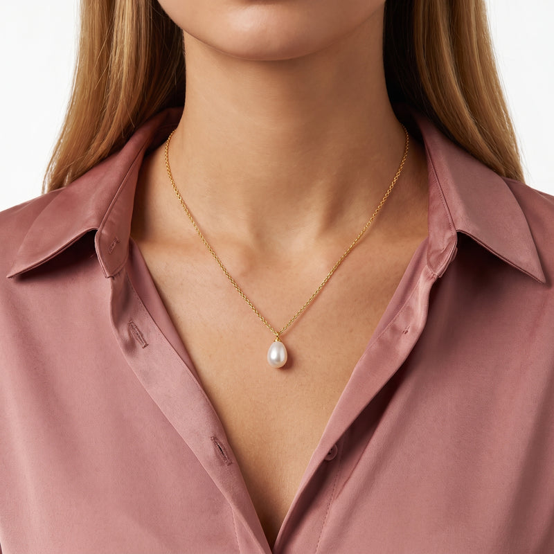 Close-up of the Lelice Teardrop Pearl Necklace in gold at the collarbone