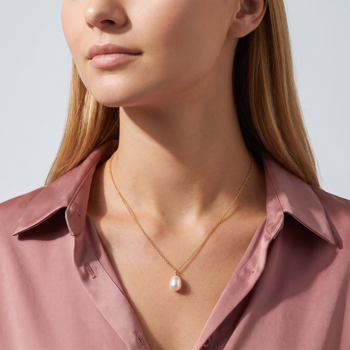 Woman in soft side light wearing the Teardrop Pearl Necklace
