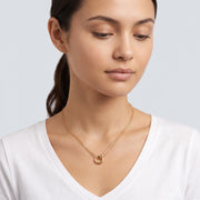 Woman looking down at the Thea Circles Necklace