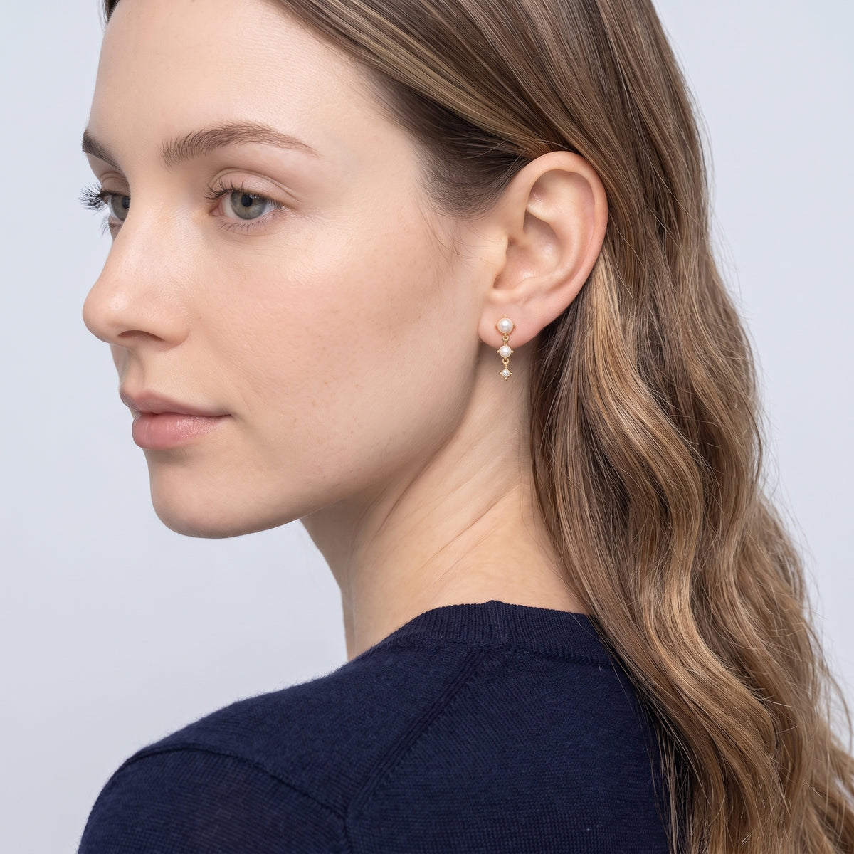 Model wearing the Lelice Trinity Pearl Drops in gold, three-quarter back view