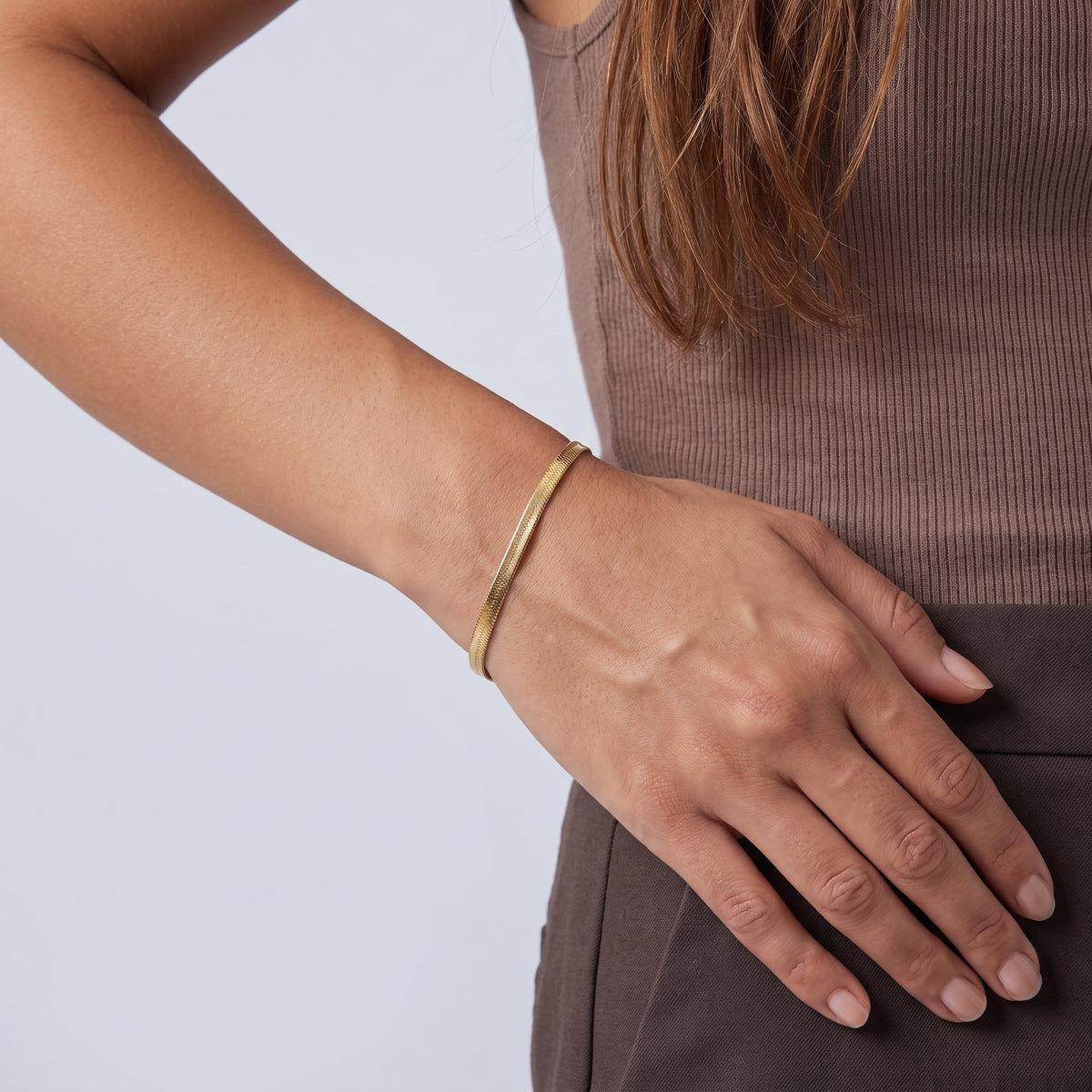 Model wearing the Lelice Vera Coil Bracelet in gold, hand on the hip