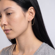 Model wearing the Lelice Victoire Chain Earrings in gold, downcast beauty portrait