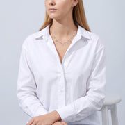 Seated woman wearing the Vivienne Drop Necklace