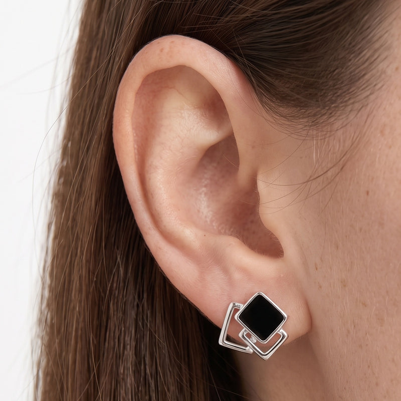 Close-up of the Lelice Yvette Black Square Studs in silver on the ear