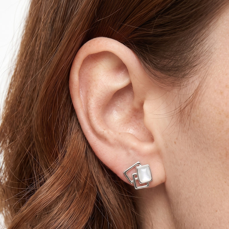 Close-up of the Lelice Yvette White Square Studs in silver on the ear