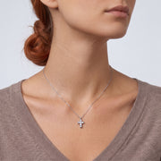 Low-angle portrait of a woman wearing the Zara Cross Necklace