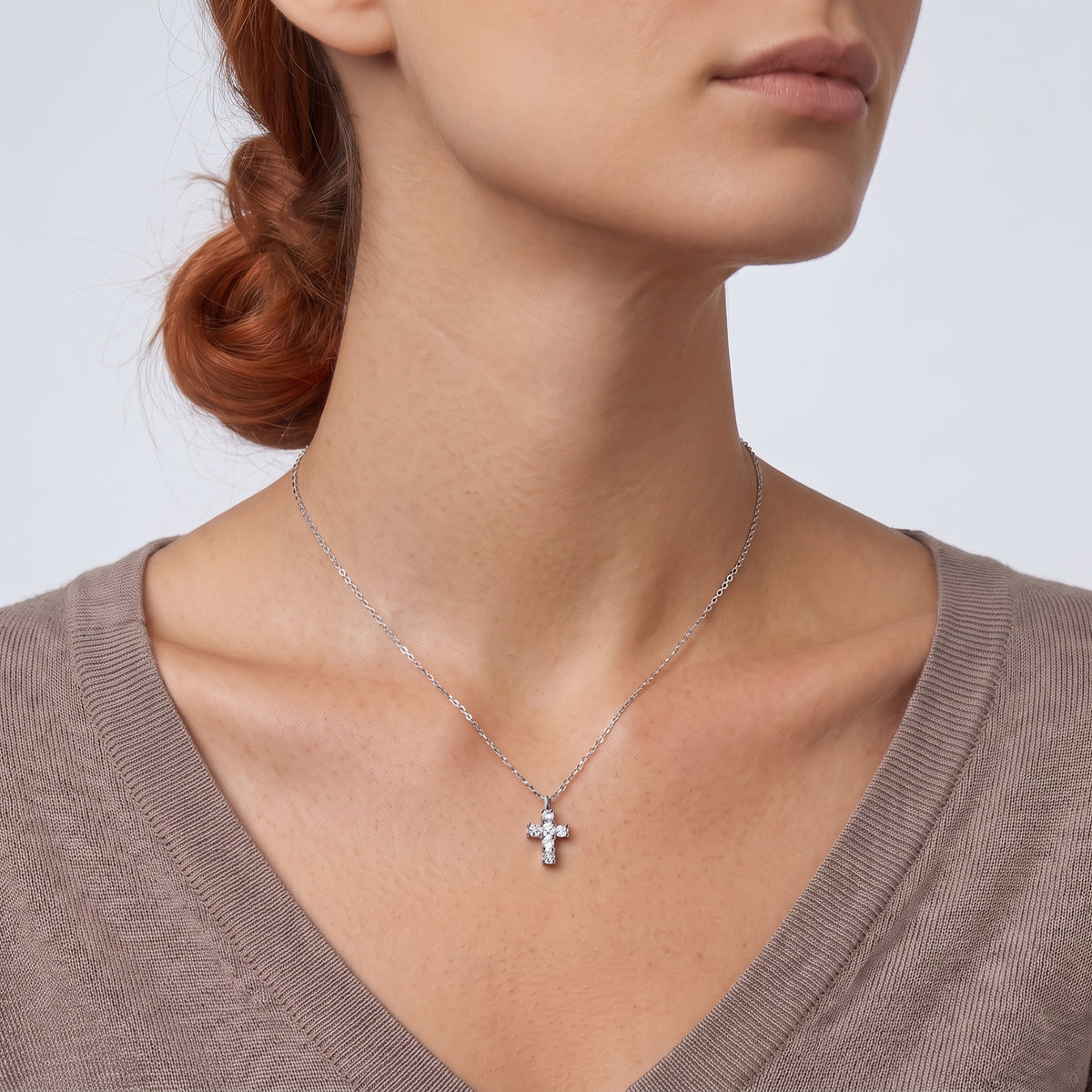Low-angle portrait of a woman wearing the Zara Cross Necklace