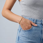Model wearing the Lelice Zoé Peridot Bracelet in gold, hand in the jeans pocket