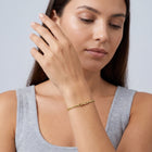Model wearing the Lelice Zoé Peridot Bracelet in gold, hand in front of the face